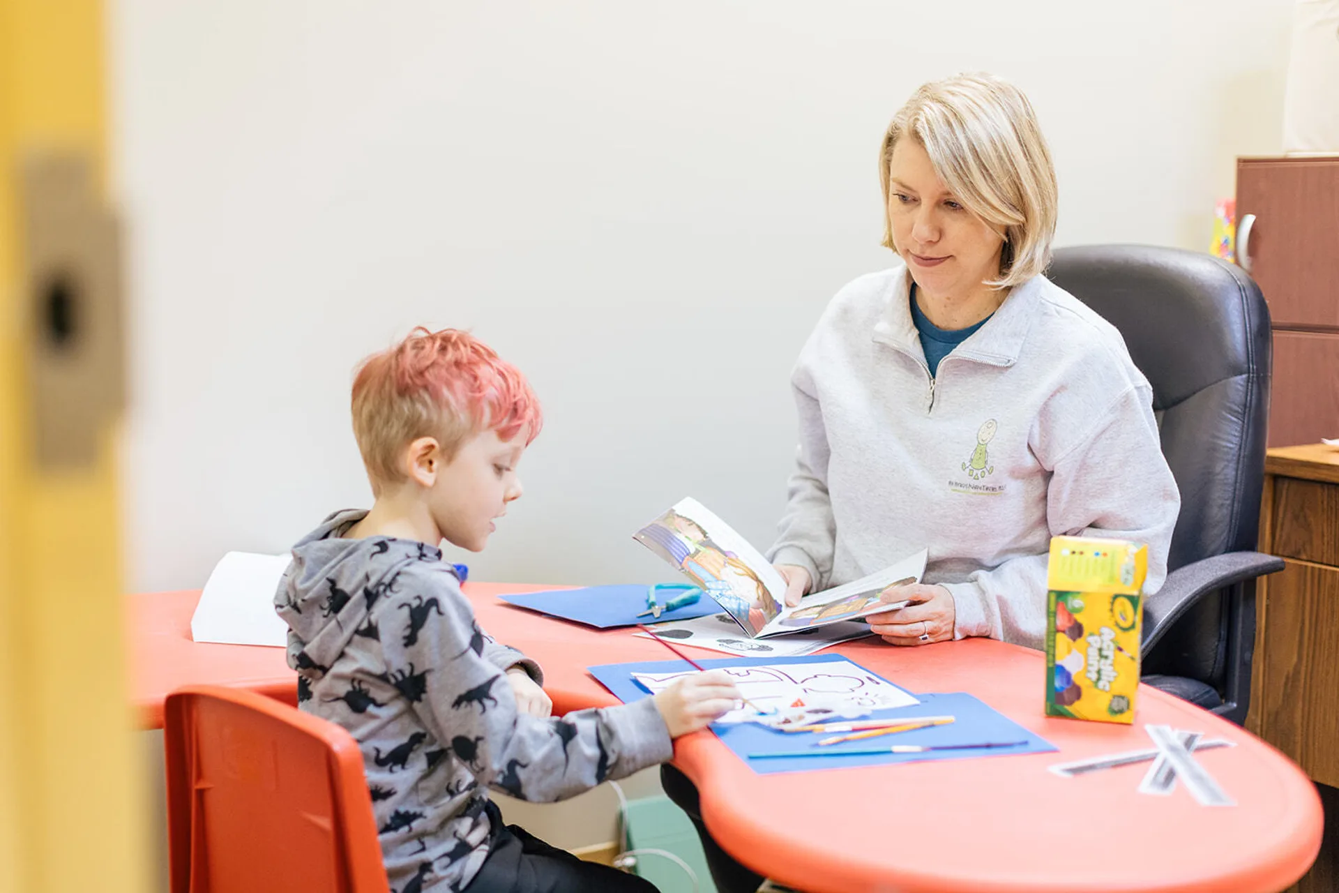 Mini Miracles employee working with a child at a desk