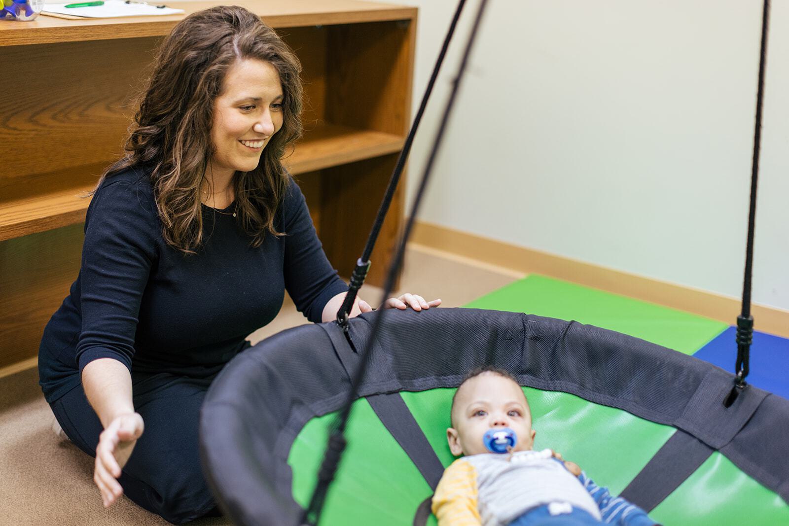 Woman pushing a child in a swing
